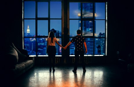 man and woman holding hands in front of glass window photo