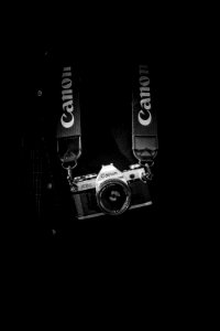 gray and black Canon camera body with lanyard photo
