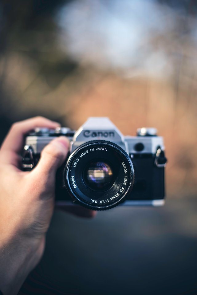 person holding black Canon DSLR camera