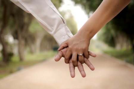 shallow focus photography of two person holding hands photo