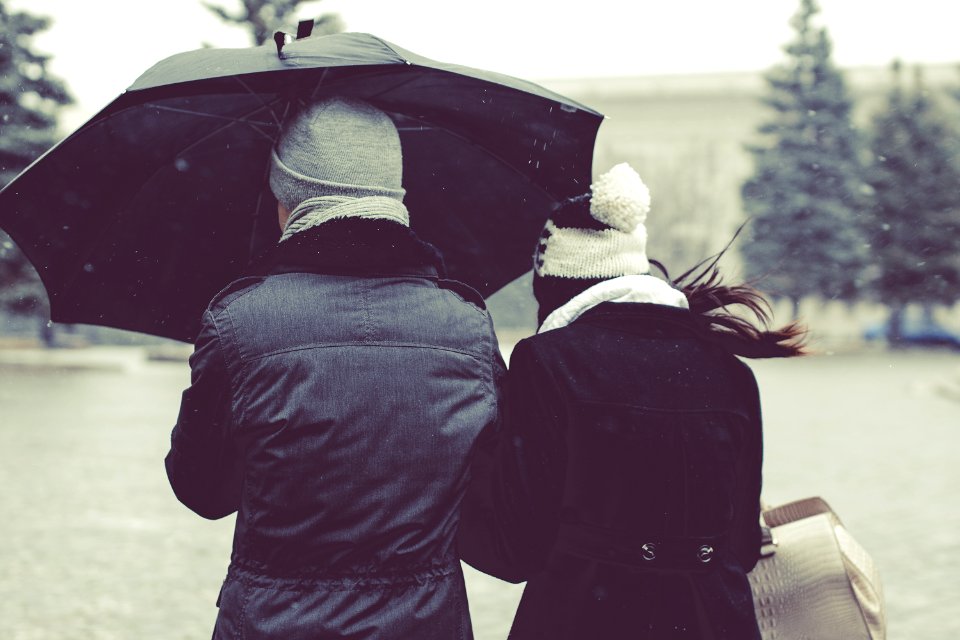 back view photography of two person under umbrella on snowy day