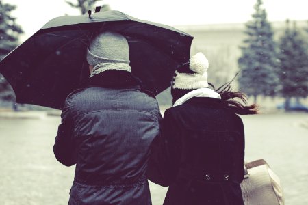 back view photography of two person under umbrella on snowy day photo
