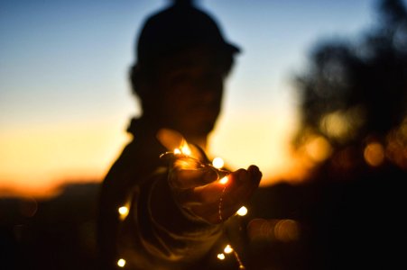 person holding string lights at nightitme photo