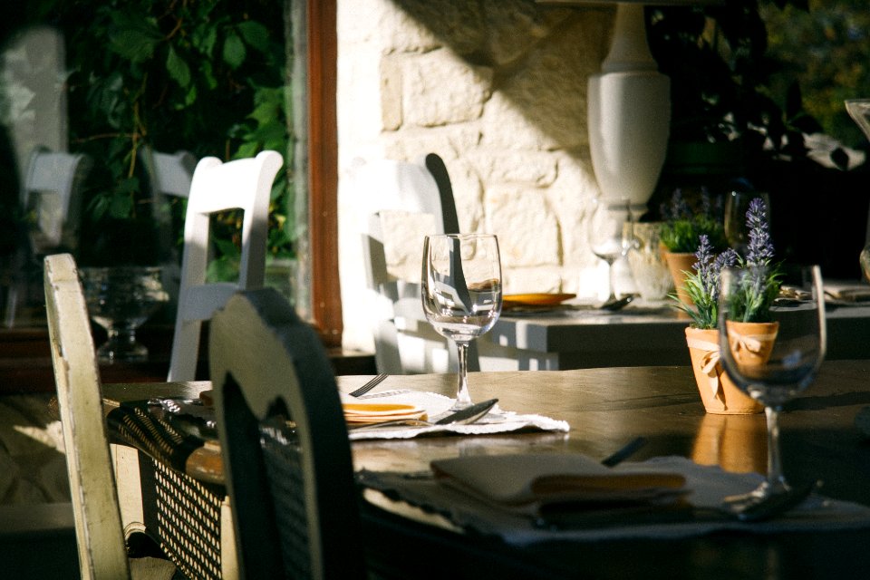 rectangular brown wooden table with wine glass
