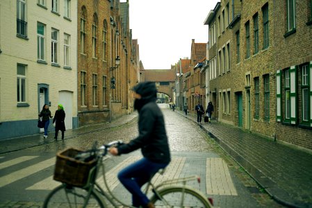 selective photography of people walking on sidewalks at side of buildings view from person riding city bicycle photo