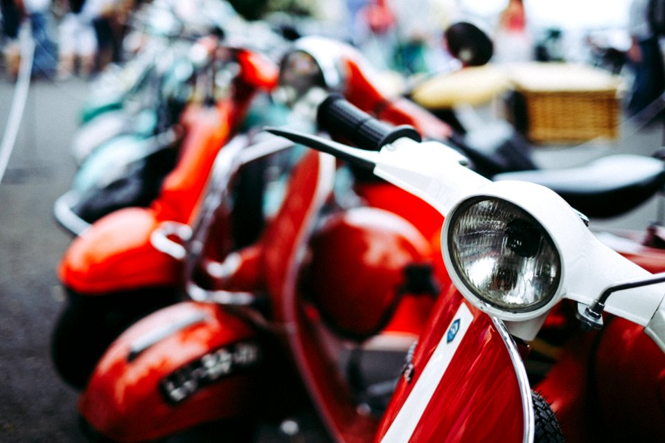 red and white motor scooter parked selective photography