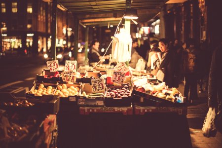 people on fruit stall beside road photo