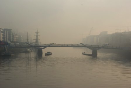 two boats below bridge with fogs