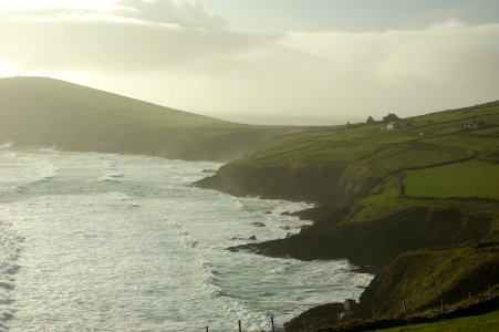 aerial photography of green field island covered with sea taken at daytime photo