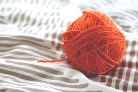 orange yarn ball on white and gray pad