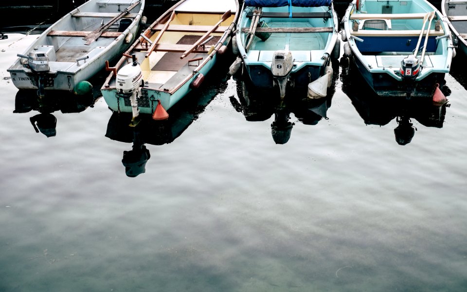 four white and blue jon boats on calm body of water
