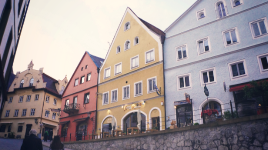 three assorted-color triangular roof houses beside road photo