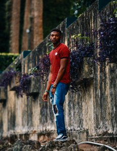 An African American man in ripped jeans and a red striped shirt. photo