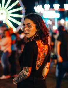 portrait photography of woman standing near Ferris Wheel photo