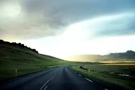 white line open road under cloudy skies photo