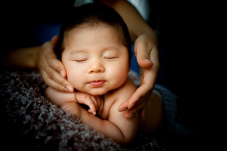 baby lying on gray textile photo