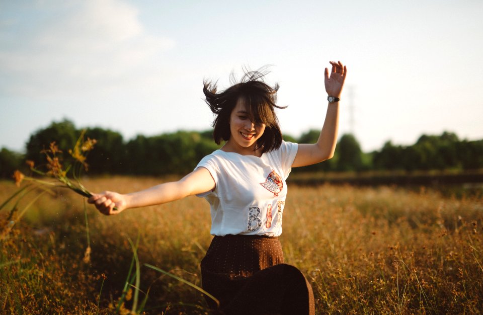 woman holding flower on field photo