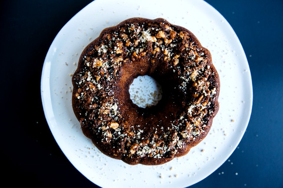 peanut sprinkled doughnut placed on round white ceramic saucer