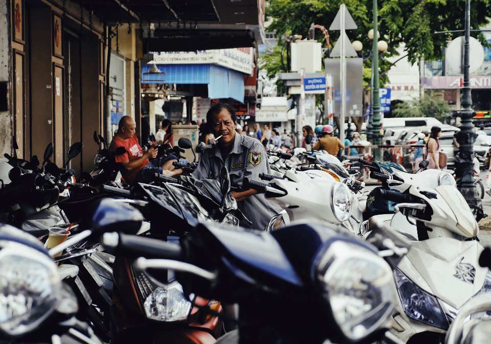man on motor scooter smoking cigarette