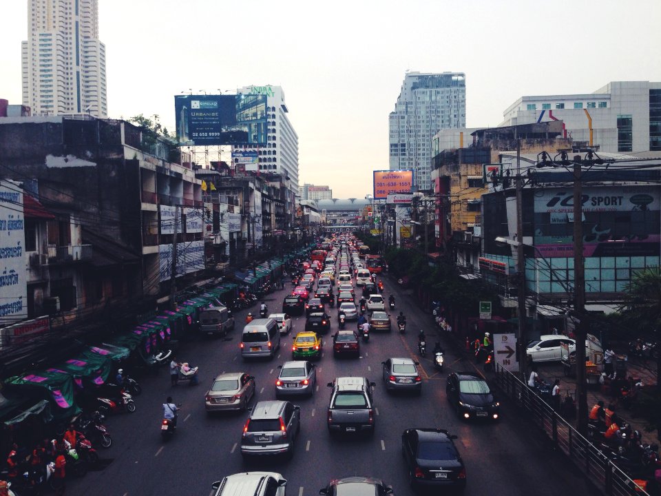 assorted cars on asphalt road beside buildings
