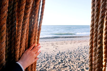 person holding brown rope over seeing body of water photo
