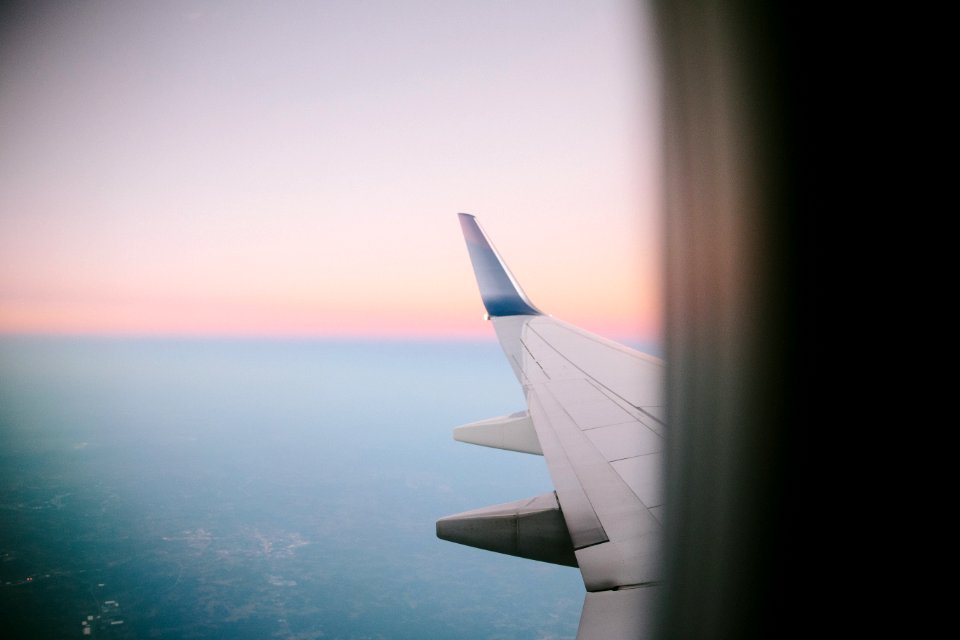 photo of the sky and airplane wing taken from inside the plane