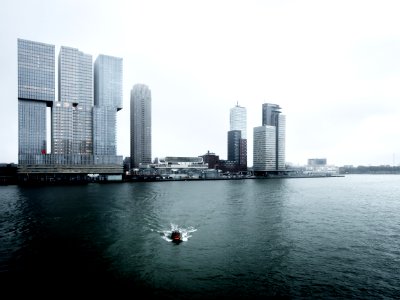 boat in the water with high-rise building in the background photo