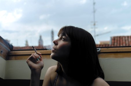 woman holding stick cigarette during day time photo