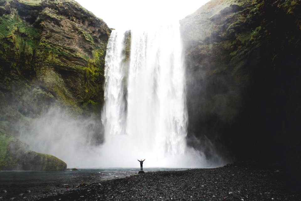 person under the waterfalls