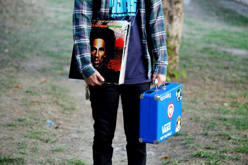 person in blue shirt holding blue suitcase