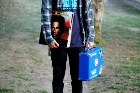person in blue shirt holding blue suitcase