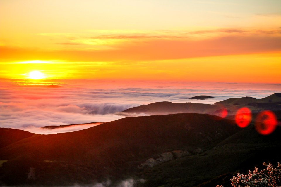 sun over the clouds and hill