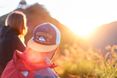 shallow photography of of man and woman sitting looking at sun rise photo