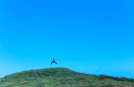 man jumping on cliff at daytime