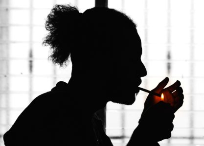 man burning single cigarette stick on his mouth photo