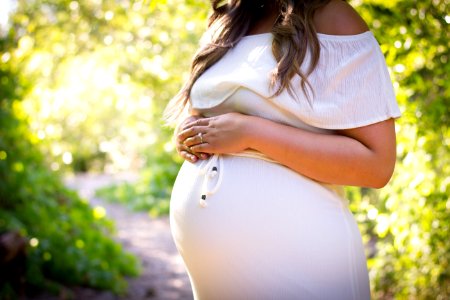 pregnant woman standing near green plants photo