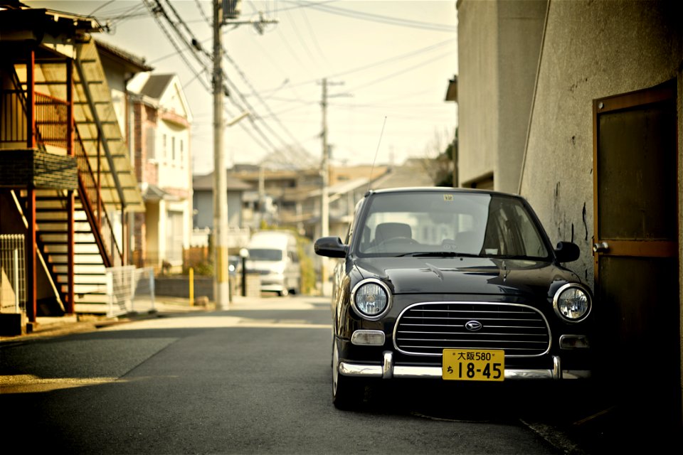 low light photography of car beside beige building