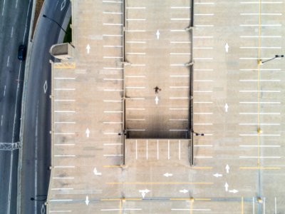 person lying on gray concrete parking area in aerial photography photo