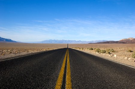 straight asphalt road between desert at daytime photo