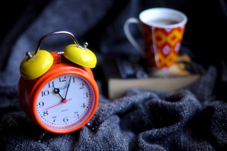 orange and yellow analog alarm clock at 11:03 photo