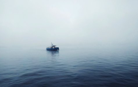 focus photo of black fishing boat on body of water photo