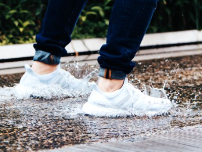 person wearing pair of gray adidas UltraBOOST low-top sneakers stepped on pool of water photo