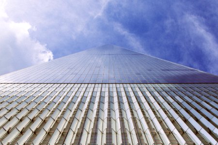 low angle photography of high-rise building under blue sky and white clouds photo