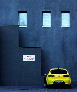 yellow SEAT car parking near concrete building photo