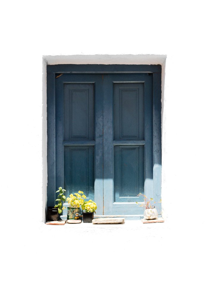 blue wooden door on white concrete wall