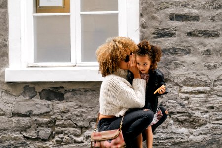 woman wearing white sweater carrying a daughter