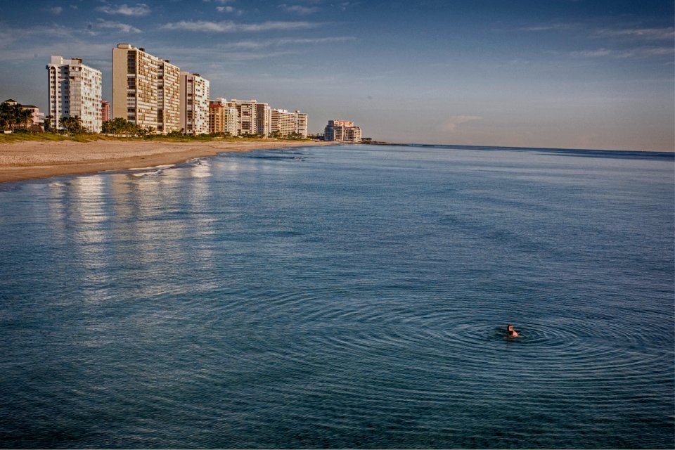person swimming in the ocean during cloudy day