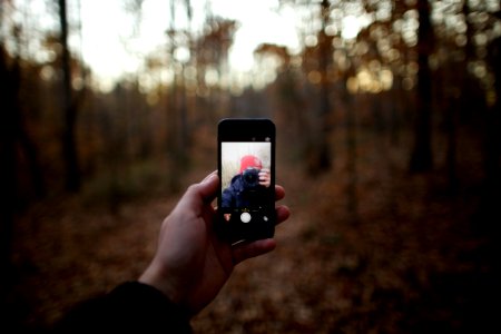 person taking selfie in forest photo