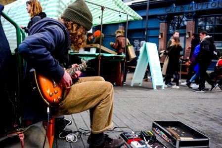man playing electric guitar near on people