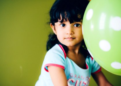 girl holding green balloon photo